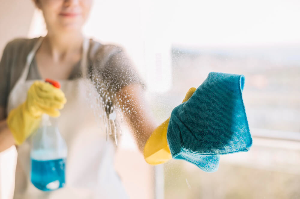 Entreprise de nettoyage - Femme qui nettoie une vitre
